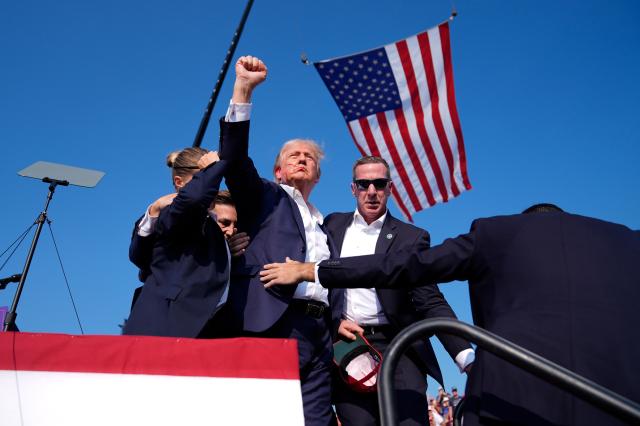 
Republican presidential candidate former President Donald Trump takes a gesture to the crowd while US Secret Service agents guide him off the stage after an attempted assassination at a campaign rally in Pennsylvania US on Jul 13 2024