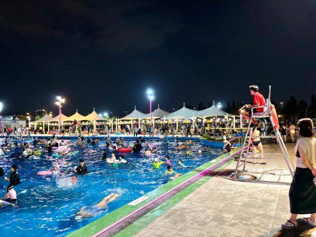 A lifeguard watches over people from a ladder at the swimming pool in Han River Park Yeouido Seoul on August 9 2024 AJU PRESS Han Jun-gu