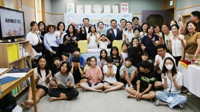 정은보 한국거래소 이사장현수막 기준 왼쪽과 이미숙 연산지역아동센터 센터장현수막 기준 가운데 주석수 연제구청장현수막 기준 오른쪽이 지난 13일 부산 연제구 KRX지역아동센터 개소식에서 지역아동센터 아동 및 관계자들과 기념 촬영을 하고 있다 사진한국거래소