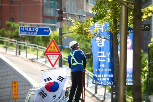 A worker hangs the national flag of Korea on a utility pole in Jongno-gu Seoul ahead of Liberation day of Korea on August 14 2024 AJU PRESS Han Jun-gu