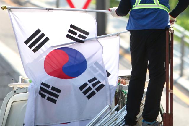 A worker hangs the national flag of Korea on a utility pole in Jongno-gu Seoul ahead of Liberation day of Korea on August 14 2024 AJU PRESS Han Jun-gu