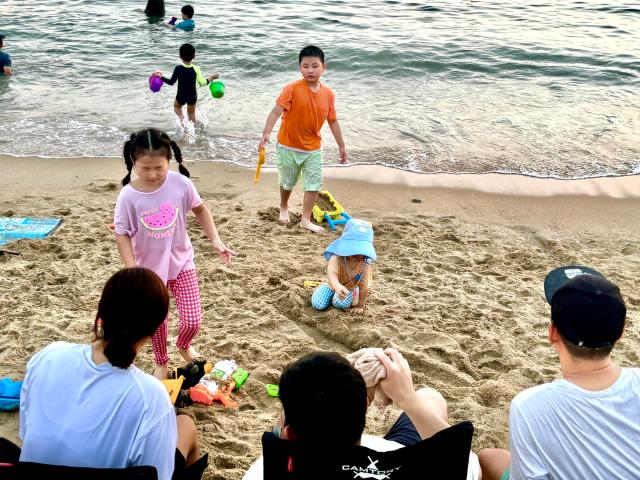 Visitors play on the sandy beach at Wangsan Beach in Incheon on Aug. 11. AJU PRESS Han Jun-gu