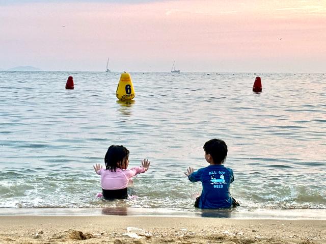 Children sit in shallow water at Wangsan Beach in Incheon on Aug 11 AJU PRESS Han Jun-gu