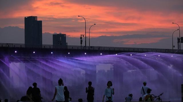 People watch a fountain under Banpo Bridge in Seoul on Thursday night Yonhap






