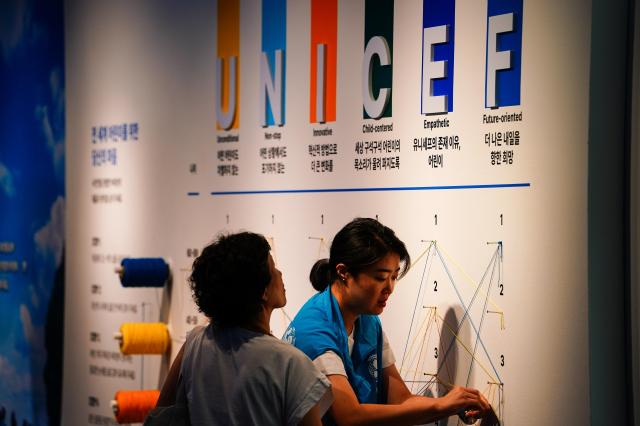 Visitors take part in a survey activity assisted by staff at For Every Children exhibit marking 30 years of The Korean Committee for UNICEF Sejong Center Aug 16 2024 AJU PRESS Park Jong-hyeok