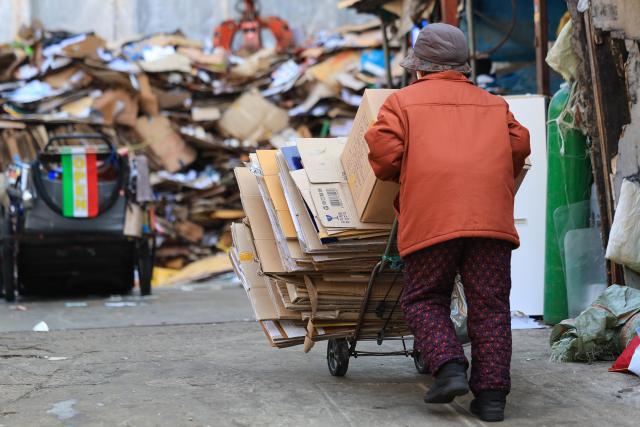 An elderly person collects cardboard for recycling South Korea Yonhap