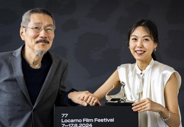 Actress Kim Min-hee and director Hong Sang-soo hold hands after she won a prize at Locarno in Locarno film festival in Switzerland on Aug 17 2024