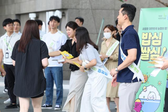 지난달 31일 서울 영등포구 여의도환승센터 인근에서 농협-한국 딜로이트 그룹 아침밥 먹기 캠페인에 참가한 한국 딜로이트 그룹 직원들이 시민들에게 농협쌀밥과 홍보물을 나눠주고 있다사진연합뉴스