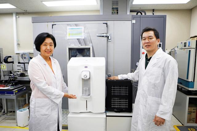 Researchers Lim Hyun-eui left and Oh Sun-jong of the Korea Institute of Machinery  Materials KIMM pose with a new portable water harvester Courtesy of KIMM