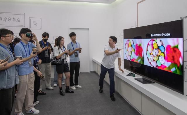 삼성전자 관계자가 AI 기술로 화면의 윤곽선과 색상을 더욱 뚜렷하게 해주는 릴루미노 모드를 시연하고 있다사진삼성전자