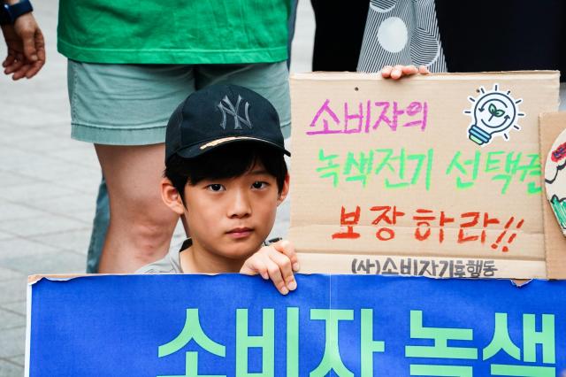 A boy at the press conference holds a sign urging the right to use renewable energy in front of Korea Electric Power Corps Seoul headquarters in Jung-gu Seoul Aug 22 2024 AJU PRESS Park Jong-hyeok