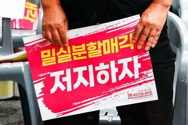 A Homeplus union representative holds a sign opposing the companys split-sale in front of MBK Partners headquarters in Jongno Seoul Aug 22 2024 AJU PRESS Park Jong-hyeok