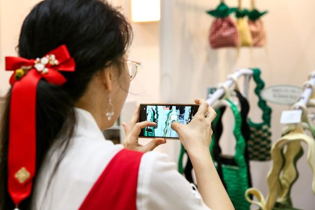 A visitor takes a photo at the Hand Arti Korea exhibition held at COEX in Seoul on Aug 22 2024 AJU PRESS Kim Dong-woo