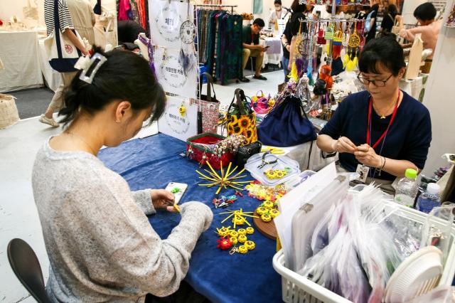 A participant engages in a handmade craft workshop at the Hand Arti Korea exhibition at COEX in Seoul on Aug 22 2024 AJU PRESS Kim Dong-woo