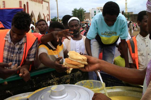 Sudanese line up to collect food portions at their temporary camp in the eastern city of Gedaref Sudan Aug 22 2024 AFP-Yonhap