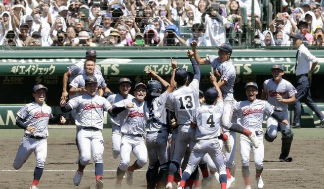 Kyoto Kokusai High School baseball players rush onto the mound to celebrate after securing a 2-1 victory in the final of the National High School Baseball Championship at Hanshin Koshien Stadium in Nishinomiya Hyogo Prefecture west Japan on Friday Yonhap