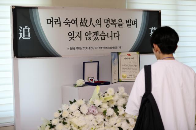 19일 오전 강원 인제군 인제읍 남북리 인제체육관에서 육군 12사단 신병교육대대 수료식이 열렸다 체육관 입구에 최근 군기훈련얼차려을 받다가 쓰러져 숨진 훈련병을 추모하는 공간이 마련돼 한 수료식 참석자가 헌화하고 있다 