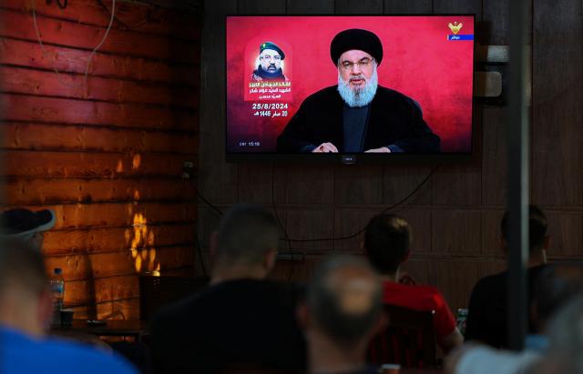 People n Beirut watch Hezbollah leader Sayyed Hassan Nasrallah give an address at a cafe in Beirut Lebanon Aug 25 2024 Reuters-Yonhap