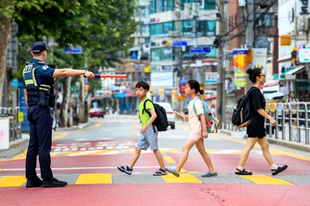 Traffic police officers guide students arriving for school in a school zone in front of Hyehwa Elementary School in Seoul on Aug 26 2024 AJU PRESS Kim Dong-woo