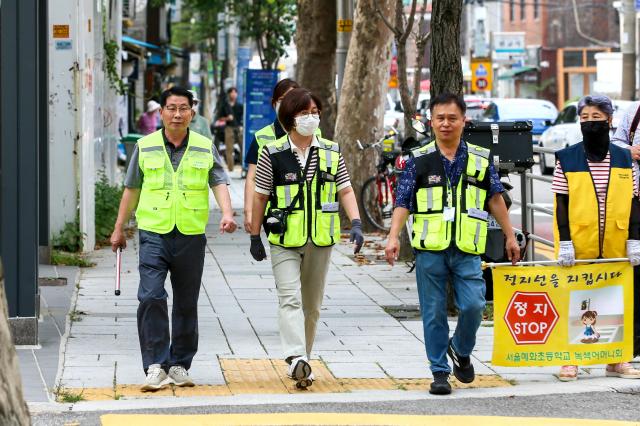 Parking enforcement officers move through a school zone in front of Hyehwa Elementary School in Seoul on Aug 26 2024 AJU PRESS Kim Dong-woo