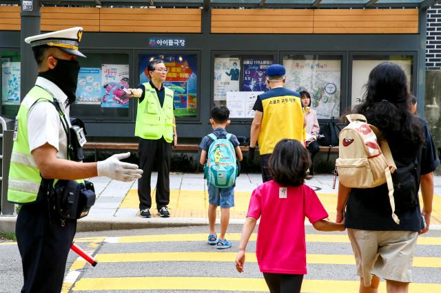 Traffic police officers guide students arriving for school in a school zone in front of Hyehwa Elementary School in Seoul on Aug 26 2024 AJU PRESS Kim Dong-woo