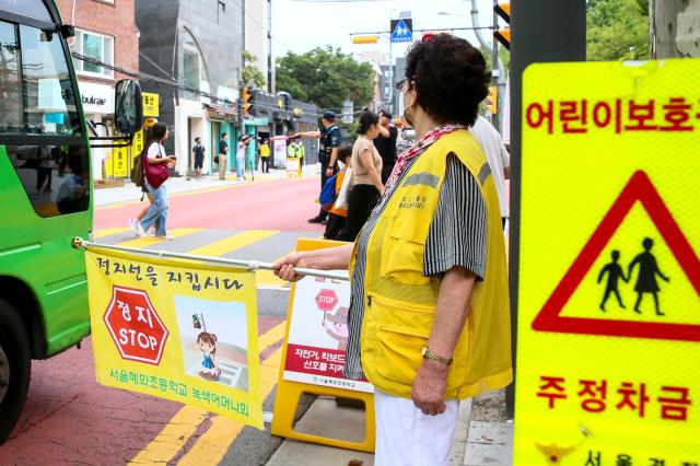 A traffic volunteer is conducting traffic guidance activities in the childrens protection zone in front of Hyehwa Elementary School in Seoul on Aug 26 2024 AJU PRESS Kim Dong-woo