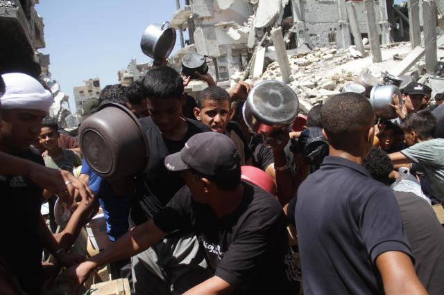 People gather to receive food at a refugee camp in the northern Gaza Strip on Aug 26 2024 Xinhua-Yonhap