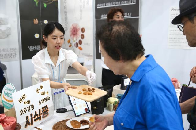 Visitors taste yakgwa traditional Korean cookies at the 2024 Festive Gift Fair at COEX in Seoul on Aug 26 2024 AJU PRESS Han Jun-gu