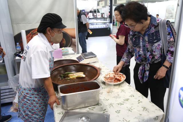 A visitor tastes kimchi at the 2024 Festive Gift Fair at COEX in Seoul on Aug 26 2024 AJU PRESS Han Jun-gu