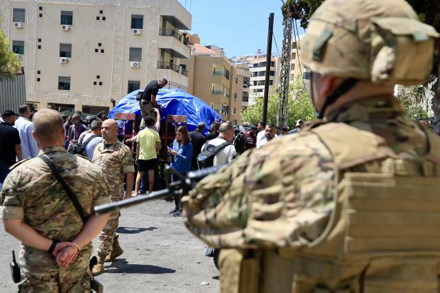 Lebanese army soldiers keep watch as workers remove a vehicle at the site that was targeted by a drone attack in Sidon southern Lebanon 26 August 2024 Lebanons state media said a man survived an Israeli drone attack targeting his car on a side road near the Al-Shamaa highway in Sidon adding that the individual is affiliated with a Palestinian organization without giving further details about his name or post There was no immediate comment from Israel on the incident  EPASTR2024-08-26 214611 Yonhap Photo