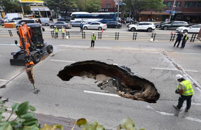 Workers fill in a sinkhole in Yonhui-dong western Seoul on Aug 29 2024 Yonhap