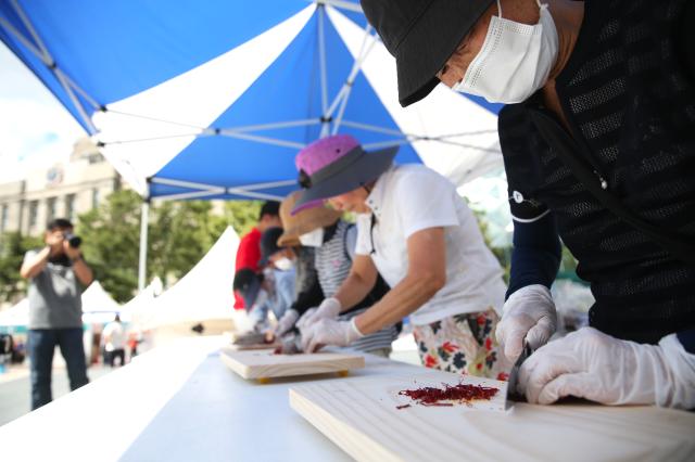 Participants cut red chilli peppers in a pepper slicing competition at the HOT Festival held in Seoul Plaza August 29 2024 AJP Han Jun-gu