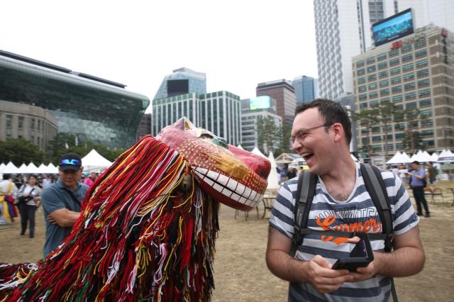 A visitor laughs while looking at a lion mask at the 2024 Seoul Market in Seoul Plaza on Sep 2 2024 AJP Han Jun-gu