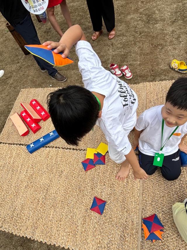 A child plays ttakjichigi traditional Korean game where players flip folded paper toys at the 2024 Seoul Market in Seoul Plaza on Sep 2 2024 AJP Han Jun-gu