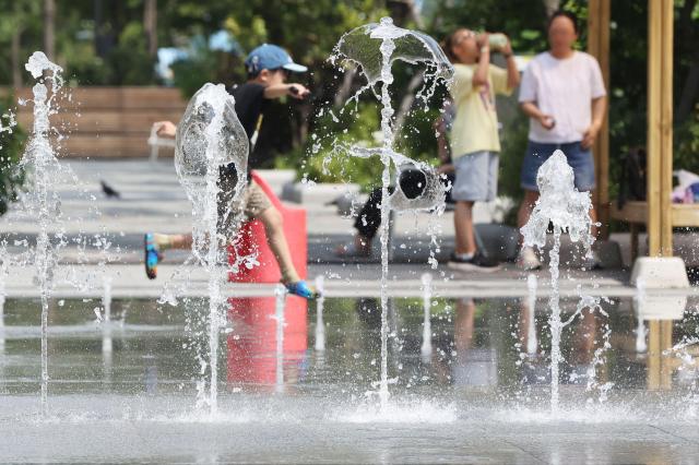 This photo shows a child playing in the fountains Yonhap