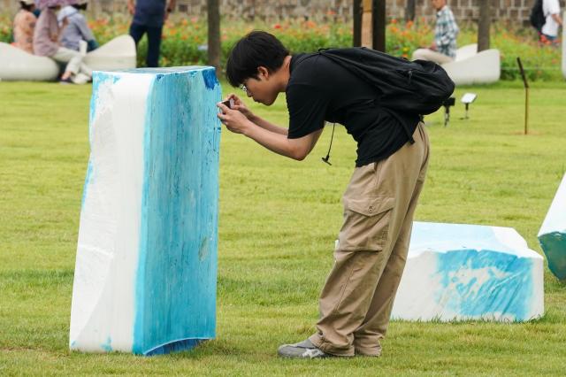 A visitor photographs the sculpture SKY+ by Kwon Hyun-bhin at the Seoul Sculpture Festival in Songhyeon Green Plaza Jongno District Seoul Monday Sept 2 2024 AJP Park Jong-hyeok