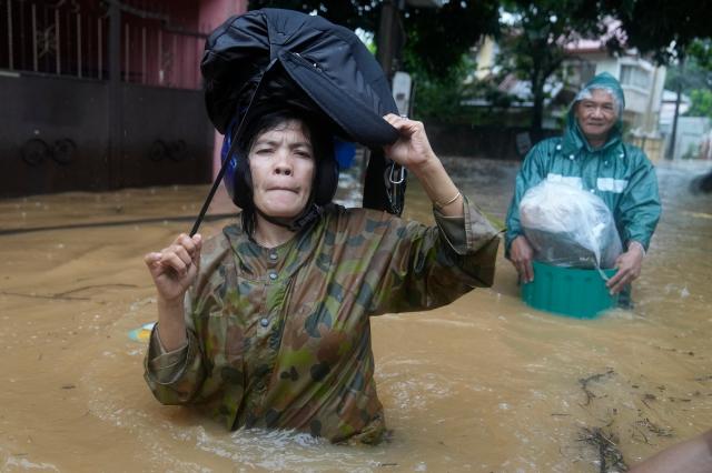 Filipinos wade through floodwaters in Rizal province carrying belongings as Storm Yagi drenches the region on September 2 2024 AP-Yonhap