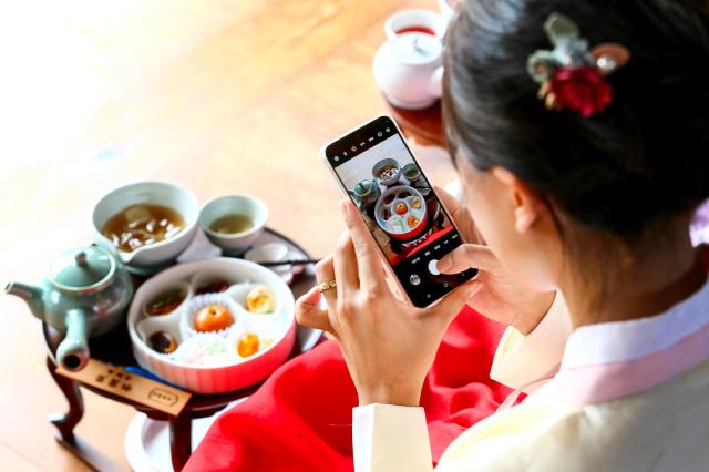 A visitor takes a photo at the Gyeongbokgung Experience of Royal Refreshments at Gyeongbokgung Palace in Jongno-gu Seoul on Sep 3 2024 AJP Kim Dong-woo