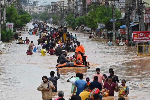 Stranded residents wade through a flooded road to reach safer places after heavy rains in Vijayawada the commercial capital of Andhra Pradesh India Sept 3 2024 AP-Yonhap