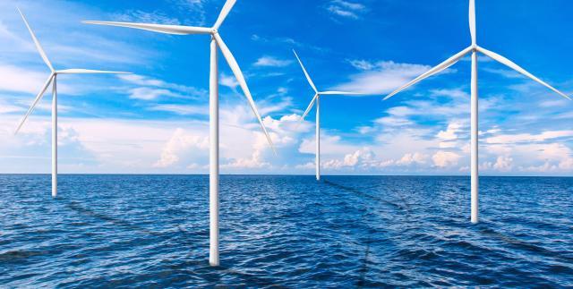 This photo shows some windmills installed off-shore spinning Getty Images Bank