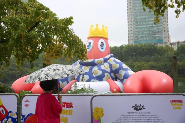 A person views the Floating Lobster King art balloon at the public art project Lobster Wonderland at Seokchon Lake Seoul Sept 6 2024 AJP Han Jun-gu