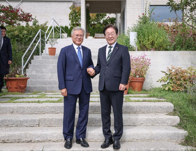 문재인 전 대통령이 8일 오후 경남 양산 평산마을 사저를 예방한 더불어민주당 이재명 대표오른쪽와 손을 잡고 기념촬영 하고 있다 사진연합뉴스