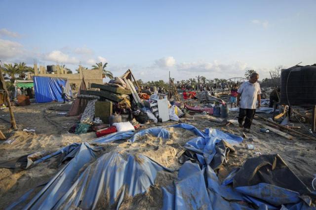 Palestinians look at the destruction after an Israeli airstrike on a crowded tent camp housing Palestinians displaced by the war in Muwasi Gaza Strip on Sept 10 2024 AP-Yonhap