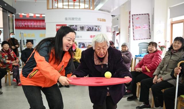 The image shows an old woman at a service center in Jiangsu Province China Xinhua-Yonhap