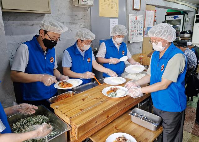 11일 오전 헌법재판소 김형두 재판관맨 왼쪽과 김정원 사무처장맨 오른쪽이 직원들과 함께 서울 종로구 탑골공원 인근에 있는 원각사 무료급식소에서 배식 봉사를 하고 있는 모습 사진헌법재판소
 