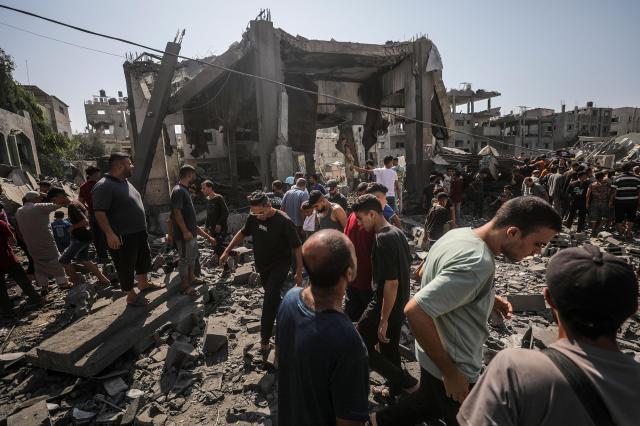 Palestinians look for missing individuals beneath the debris of a destroyed building after an Israeli airstrike in a refugee camp in central Gaza Strip on Sept 10 2024