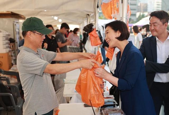 오영주 중소벤처기업부 장관이 지난 10일 서울 종로구 청계광장에서 열린 동행축제 전통시장 판매전에서 판매 부스를 둘러보며 제품을 구매하고 있다 사진연합뉴스