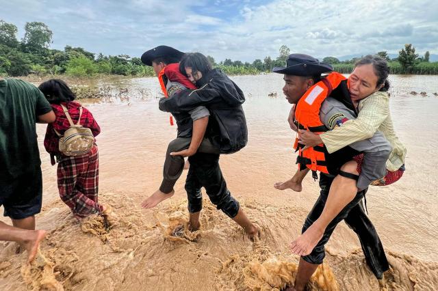 Police carry residents affected by flooding through floodwaters in Pyinmana town on September 13 2024 AFP-Yonhap