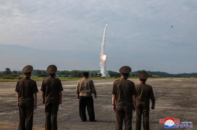 North Korean leader Kim Jong-un and military officials overlook the test-fire of two tactical missiles at a launch site near Kasong City on Sept 18 KCNAYonhap 