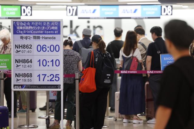 Travelers line up in front of a check-in counter for a flight to Haneda Japan at Gimpo Airport Korea in this file photo taken in June 2024 Yonhap